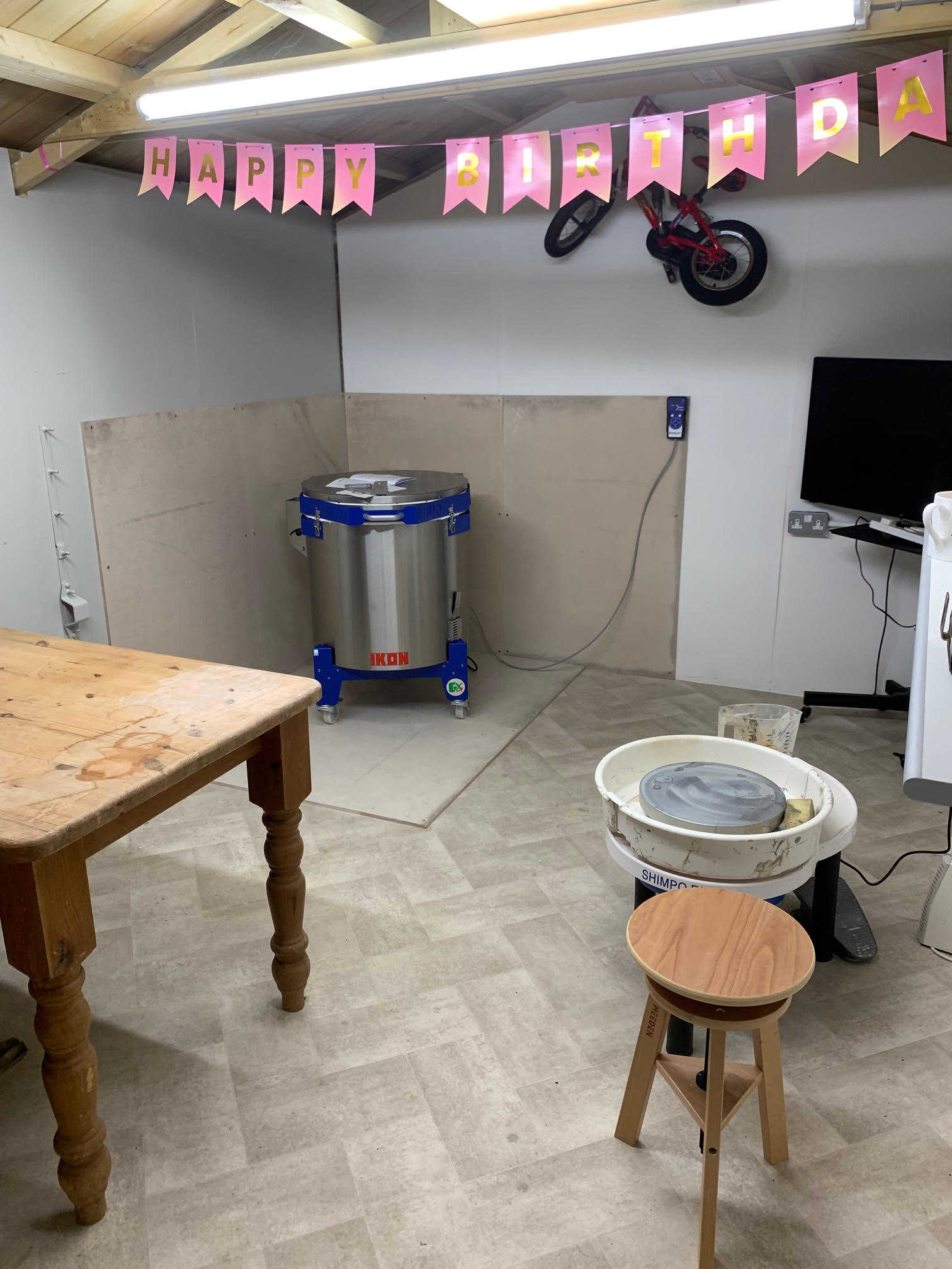 Pottery kiln in home studio with pottery wheel