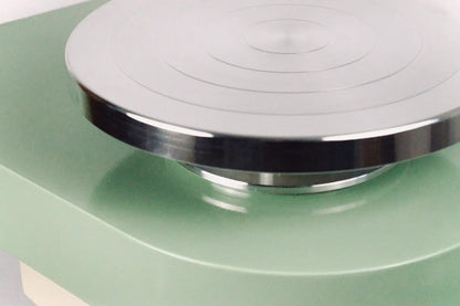 close up of metal wheelhead on green pottery wheel